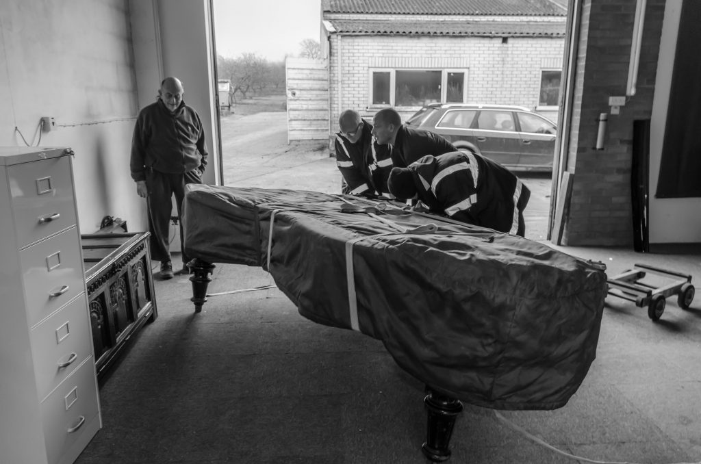 Moving a grand piano onto legs- Colin Batt Removals -Canterbury